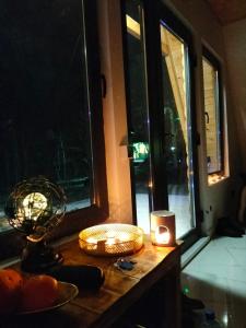 um quarto com uma mesa com uma vela e uma janela em Cabana A Morarului em Teiuş