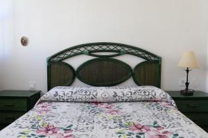1 dormitorio con 1 cama con colcha de flores en Apto con Piscina en Garrucha en Garrucha