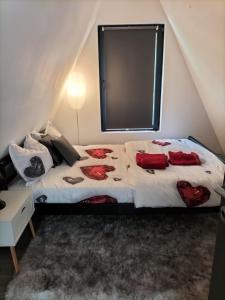 um quarto com uma cama com almofadas vermelhas em Cabana A Morarului em Teiuş