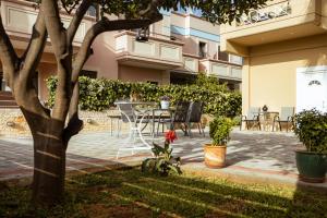 a patio with a table and chairs next to a building at Plakoures Home in Kounoupidhianá