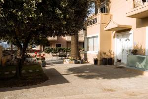 a building with a tree next to a sidewalk at Plakoures Home in Kounoupidhianá