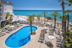 een luchtzicht op een resort met een zwembad en het strand bij Caprici Beach Hotel & Spa in Santa Susanna