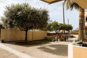 a tree in a yard next to a fence at Plakoures Home in Kounoupidhianá