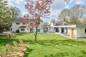 a group of chairs on a lawn in front of a house at Cheltenham's Most Luxurious House - Beautiful Hot Tub & Indoor Pool in Charlton Kings