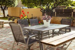 a table and chairs with a vase of flowers on it at Plakoures Home in Kounoupidhianá