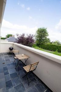 a patio with two chairs and a table on a balcony at The Stillorgan Village in Dublin