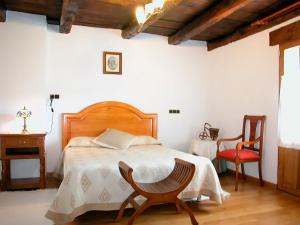 een slaapkamer met een bed, een stoel en een tafel bij Casa Rural Pierresena en Larrayoz, Navarra in Arístregui