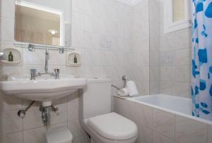 La salle de bains est pourvue de toilettes, d'un lavabo et d'une baignoire. dans l'établissement Baywatch Apartments on the Beach, à Amoudi