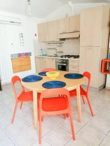 cocina con mesa y 4 sillas en Homiday - Tamerici Attico, en Pineto