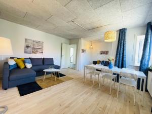 a living room with a blue couch and a table at aday - Northern light apartment in Frederikshavn