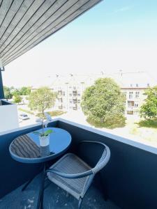 a small table and a chair on a balcony at aday - Northern light apartment in Frederikshavn