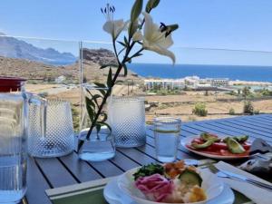 a table with plates of food and a vase with flowers at Vivelorural Agaete 2D infinity pool & great views in Agaete