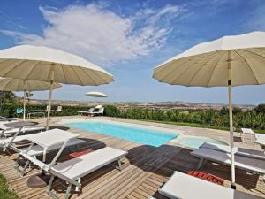 a villa with a swimming pool and umbrellas at Cottage in Montelabbate with Pool Garden BBQ Parking in Montelabbate