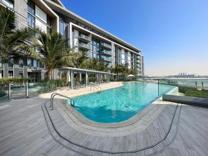 a large swimming pool in front of a building at VayK - Spacious One Bedroom with Ain Views in Dubai