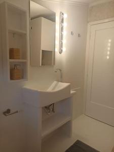 Baño blanco con lavabo y espejo en Cozy house en Tagarades