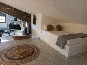 1 dormitorio con 1 cama grande y chimenea en Cozy house en Tagarades