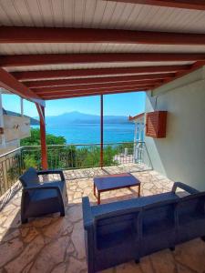 a patio with couches and a view of the ocean at Beach front apartment Psili Ammos in Psili Ammos