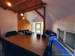 - un salon avec une grande table et des chaises en bois dans l'établissement Apartament, à Oboźna Droga Masłów