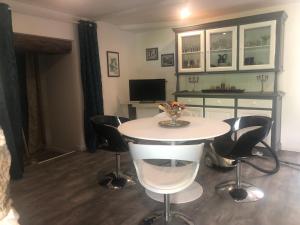 ボズールにあるLes rives du Dourdouの白いテーブルと椅子のあるダイニングルーム