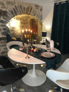 a dining room with a table with candles and chairs at Les rives du Dourdou in Bozouls