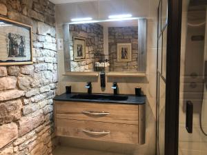 ボズールにあるLes rives du Dourdouの洗面台と石の壁のあるバスルーム +4枚の写真