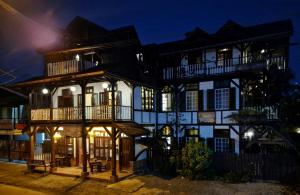 a large building with a porch and balconies at night at Greenheart Boutique Hotel in Paramaribo