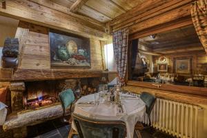 a dining room with a table and a fireplace at Le Vieux Chalet in La Clusaz +19 photos