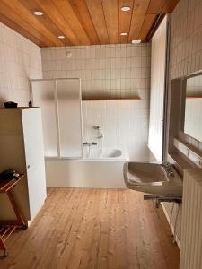 La salle de bains est pourvue d'une baignoire et d'un lavabo. dans l'établissement B&B The White House, à Wielsbeke