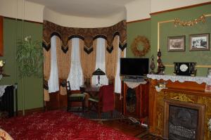 a living room with a fireplace and a tv at Schuster Mansion Bed & Breakfast in Milwaukee