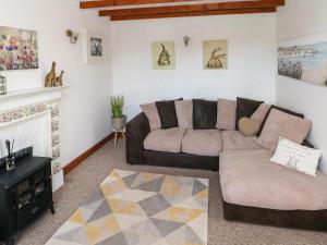 sala de estar con sofá y chimenea en Daisys Cottage, en Burry Port