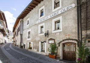 a building with a sign on it on a street at Le Coeur du Pont in Donnaz