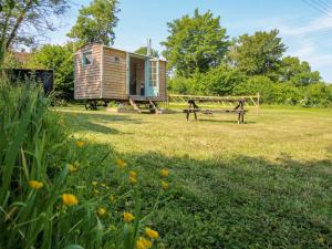 a tiny house in a field with a bench at Acres Meadow in Dorchester
