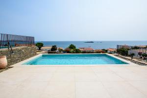 een zwembad met de oceaan op de achtergrond bij Can Bailet in Cadaqués