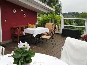 una terraza de madera con mesa y sillas. en Rosenhof Ferienwohnungen, en Mölln-Medow
