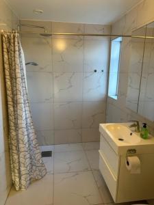 biała łazienka z prysznicem i umywalką w obiekcie Kulladal Malmö w Malmö