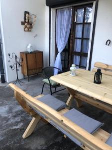 drewniany stół i ławka w pokoju z oknem w obiekcie Dom Mossa w mieście Stara Rzeka