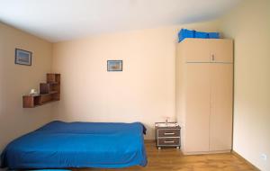 a bedroom with a blue bed and a cabinet at Domek na Mazurach in Mrągowo
