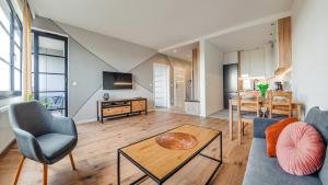 a living room with a couch and a table at Apartamenty Sun & Snow Doki in Gdańsk