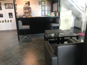 a barber shop with a table and chairs in a room at Agathas Hotel powered by Cocotel in Quezon