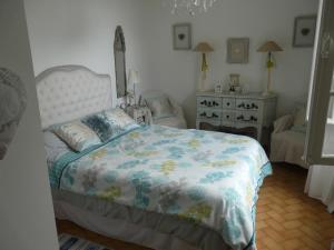 - une chambre avec un lit, une chaise et une commode dans l'établissement MAISON Classée 3*, à Gujan-Mestras