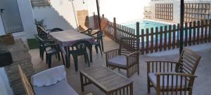 un patio con tavolo, sedie e piscina di CASA RURAL EN GRANADA CON CHIMENEA, PISCINA PRIVADA Y BARBACOA LA CASITA DE TóZAR a Tózar