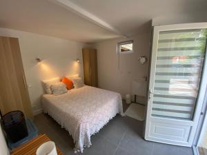 1 dormitorio con cama blanca y ventana en Maison proximité centre-ville, en Arcachon