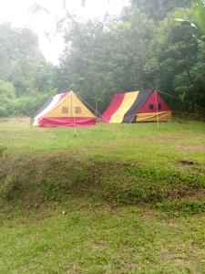 duas tendas sentadas num campo à chuva em Tapian Ratu Camp em Bukittinggi