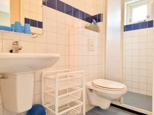 y baño con aseo blanco y lavamanos. en Vakantiewoning Domburg DO34, en Domburg
