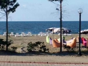 una playa con sillas y sombrillas y el océano en Kocaali Sun Otel en Sakarya