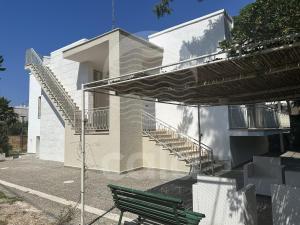 een groene bank voor een gebouw met trappen bij Villa Capitano - piscina privata By Cala Salento in Torre Lapillo