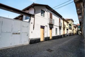 una calle vacía con un edificio blanco y una valla en Margot Family en Venaria Reale