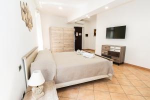 a bedroom with a bed and a dresser and a television at Margot Family in Venaria Reale