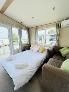 a bedroom with a large bed and a couch at Haven Holiday Home at Kent Coast Allhallows in Rochester