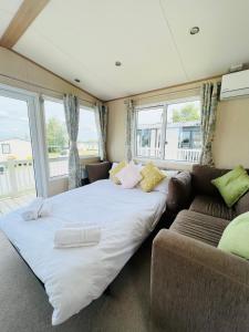 a bedroom with a large bed and a couch at Haven Holiday Home at Kent Coast Allhallows in Allhallows